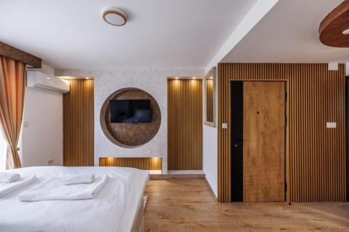 a bedroom with a white bed and a mirror at Hotel Mažijanik in Nikšić