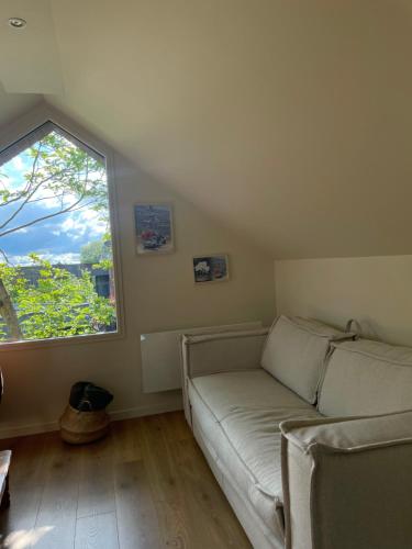 a living room with a couch and a large window at Gîte charmant indépendant in Fournes-en-Weppes