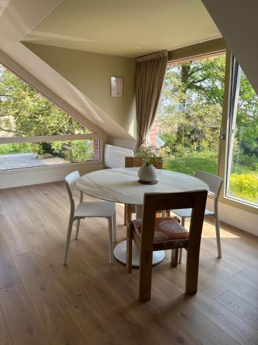 a dining room with a table and chairs and a window at Gîte charmant indépendant in Fournes-en-Weppes