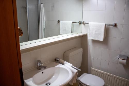 a bathroom with a sink and a toilet and a mirror at Appartement Achtern Diek 2-23 in Dorum-Neufeld