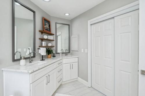 a white bathroom with two sinks and a large door at FEATURED ON HGTV'S MY LOTTERY DREAM HOME! Private dock, 15 minute boat ride to Crab Island, 20 minute drive to Destin, Pet Friendly in Niceville
