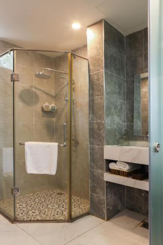 a bathroom with a shower with a glass door at Art Hotel Ha Noi in Hanoi