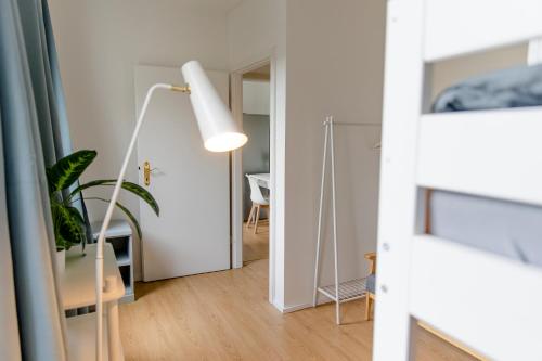 a living room with a mirror and a lamp at Leopold's Apartments mit Garten und Vesteblick Mitten in Coburg in Coburg