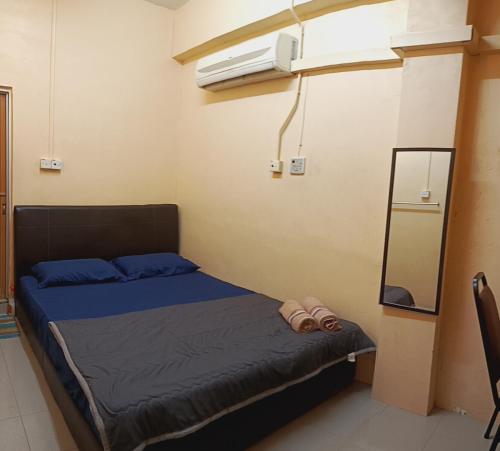 a bedroom with a bed and a air conditioner at Hotel Bajet Gaya Warisan in Kota Bharu