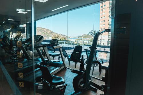 a gym with cardio equipment and a view of the water at Golden Tulip Porto Vitória in Vitória