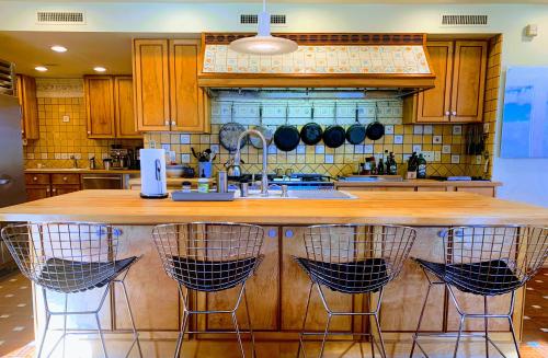 a kitchen with a large wooden island with bar stools at NewVida Preserve in Wilmington