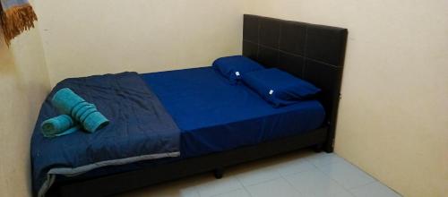 a small bed in a room with blue sheets and pillows at Hotel Bajet Gaya Warisan in Kota Bharu
