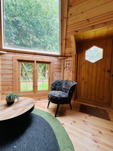 a room with a chair and a table in a cabin at Bed & Breakfast Voor De Wind in Slootdorp