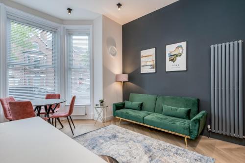 a living room with a green couch and a table at Bliss Stay Belfast University Street in Belfast