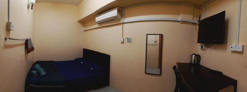 a small room with a bed and a mirror at Hotel Bajet Gaya Warisan in Kota Bharu