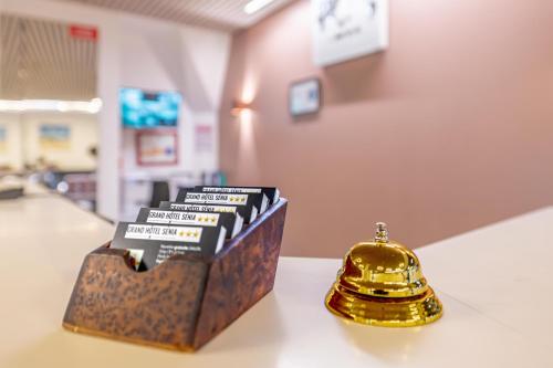 a box of books on a table with a bell at Grand Hotel Sénia - Paris Orly Airport in Orly