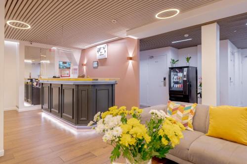 a lobby with a couch and a bar in a store at Grand Hotel Sénia - Paris Orly Airport in Orly