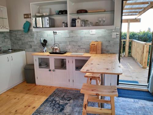 a kitchen with a counter and a wooden table at C es Cape in Pringle Bay