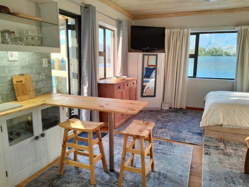 a room with a table and two stools in it at C es Cape in Pringle Bay