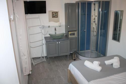ein Bad mit einem Bett, einer Dusche und einem Waschbecken in der Unterkunft Logis Hotel Chemin Des Dames Le Relais De Fleurette in Pontavert