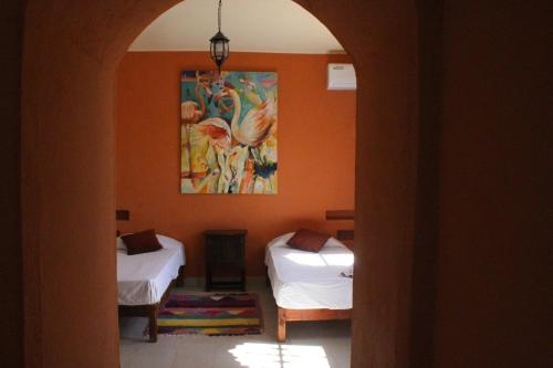 a room with two beds and a painting on the wall at Domaine El Htouba in Korba