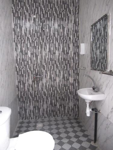 a bathroom with a shower with a sink and a toilet at Résidence Séjour Téranga in Saint-Louis
