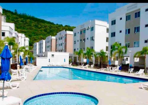 een zwembad in een hotel met stoelen en gebouwen bij Praia canavieiras in Florianópolis
