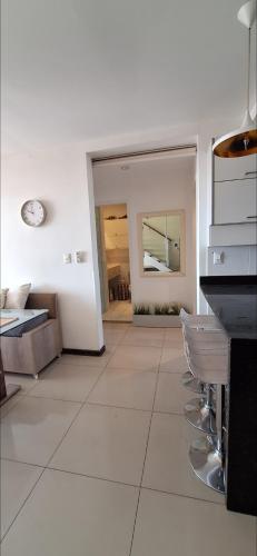 a kitchen with white walls and a counter and chairs at Penthouse ROBELINI - Terraza, jacuzzi & vistas in Asuncion