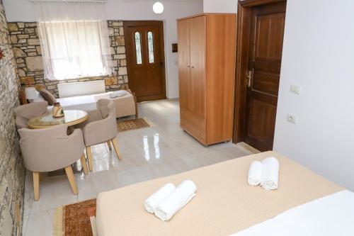 a room with two beds and a table and a living room at Stone House Berat in Dushnik