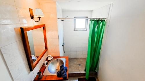 a bathroom with a shower with a sink and a mirror at En calma in Punta Del Diablo