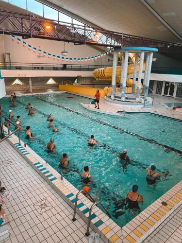 un groupe de personnes dans une piscine dans l'établissement Appartement calme près des métros et des JO 2024, à Saint-Denis