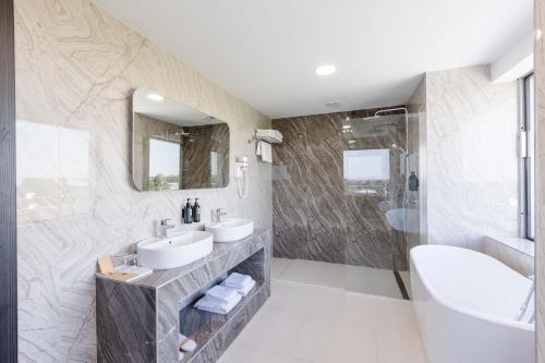 a bathroom with two sinks and a shower at Ramada by Wyndham Bucharest Otopeni Airport in Otopeni