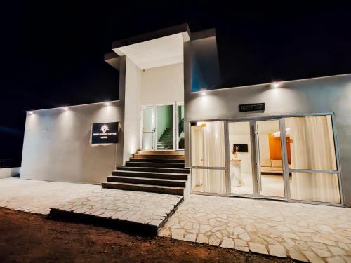 a building with a staircase leading to a building with glass doors at Sunset Shoreline Saranda - Sea View - Free Private Parking - Pool in Sarandë