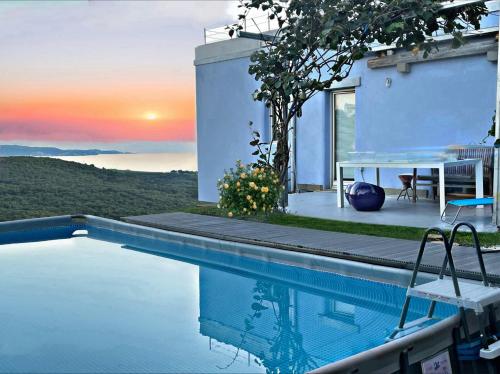 a villa with a swimming pool with a sunset in the background at VILLA mandala in Ankaran
