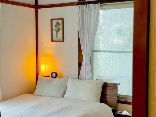 a bedroom with a bed and a large window at ハルノヒハウス-春日部の民泊- Spring Day House in Kasukabe in Kasukabe