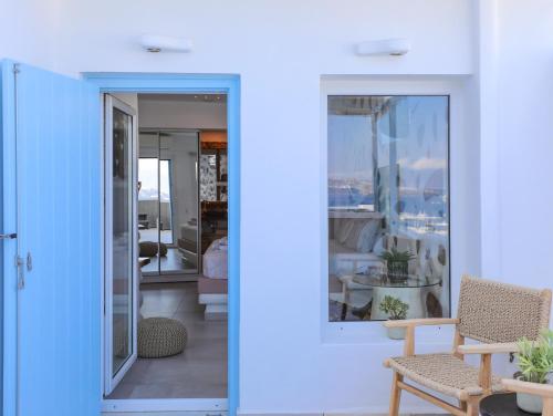 a room with a blue door and a table and chairs at Ibiscus Boutique in Mýkonos City