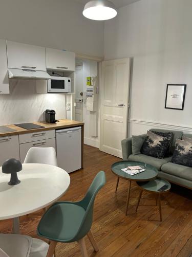 un salon avec un canapé, une table et des chaises dans l'établissement Le Toulousain 001 - Appartement calme en rez-de-chaussée avec Terrasse - Hypercentre, quartier Jeanne d'Arc, à Toulouse