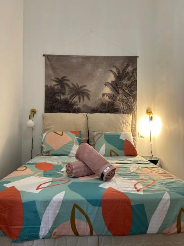 - un lit avec une couette et des oreillers colorés dans l'établissement Le Toulousain 001 - Appartement calme en rez-de-chaussée avec Terrasse - Hypercentre, quartier Jeanne d'Arc, à Toulouse