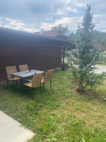a table and chairs in a yard with a tree at Kathreinkogelblick in Schiefling am See