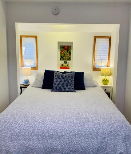 a bedroom with a large white bed with blue pillows at Bluebird Day - River Gem Bungalow in Bend