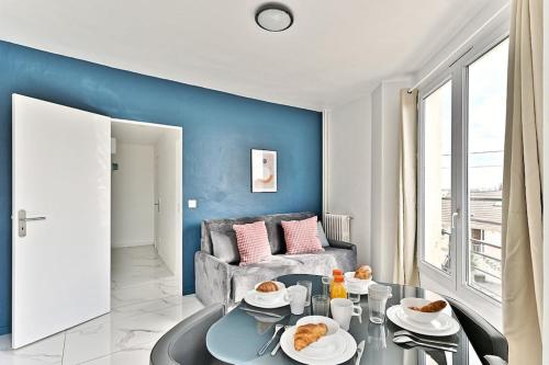 un salon avec une table et un canapé dans l'établissement Appartement conviviale et lumineux - III, à Gournay-sur-Marne