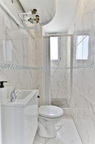une salle de bain blanche avec des toilettes et un lavabo dans l'établissement Appartement conviviale et lumineux - III, à Gournay-sur-Marne