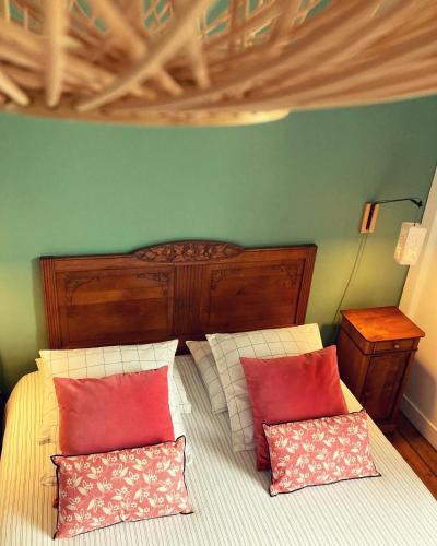 a bedroom with a bed with red and white pillows at Léhontine in Dinan