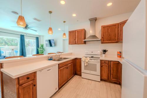 a kitchen with wooden cabinets and white appliances at Marisol 101 in South Padre Island