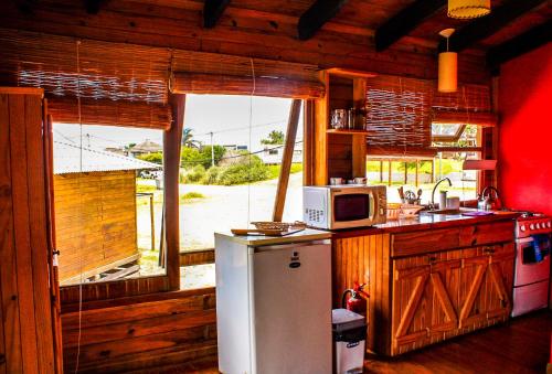 a kitchen with a refrigerator and a microwave at En calma in Punta Del Diablo
