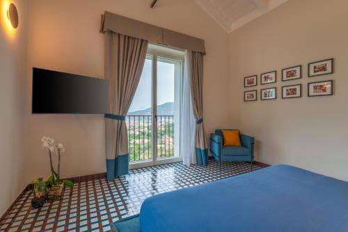 a bedroom with a blue bed and a large window at Gargiulo Resort in Sant'Agnello