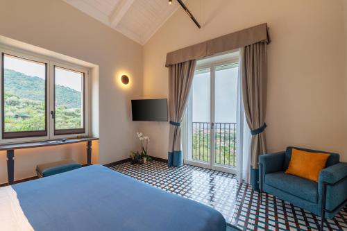 a bedroom with a bed and a chair and windows at Gargiulo Resort in Sant'Agnello