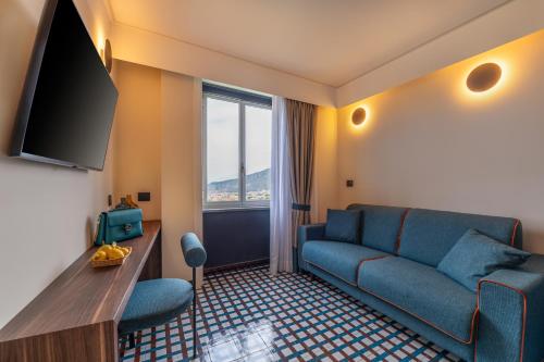 a living room with a blue couch and a large window at Gargiulo Resort in Sant'Agnello