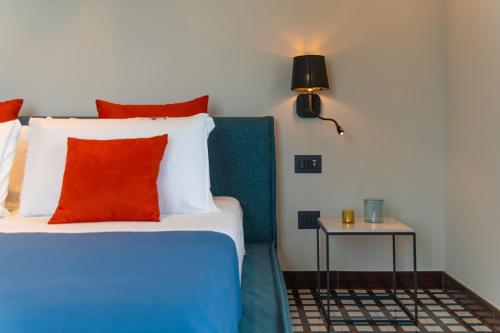 a bedroom with a bed with red pillows and a side table at Gargiulo Resort in Sant'Agnello