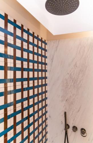 a bathroom with a shower with blue and white tiles at Gargiulo Resort in Sant'Agnello