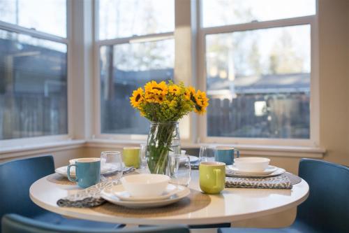 a table with a vase of yellow flowers on it at Bluebird Day - High Desert Dwell in Bend