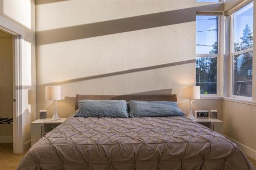 a bedroom with a large bed and two windows at Bluebird Day - High Desert Dwell in Bend