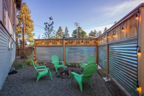 a backyard with green chairs and a fire pit at Bluebird Day - High Desert Dwell in Bend