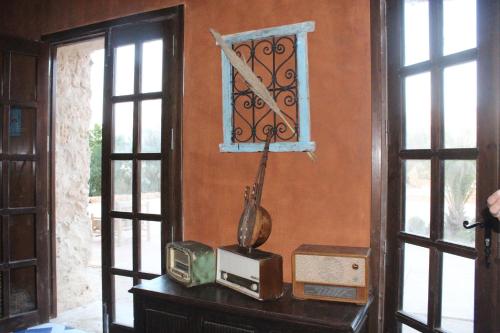 a room with a table with a vase and a window at Domaine El Htouba in Korba