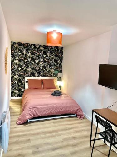 - une chambre avec un lit rose et un bureau dans l'établissement T4 plein coeur de Marseille avec vue Notre Dame, à Marseille